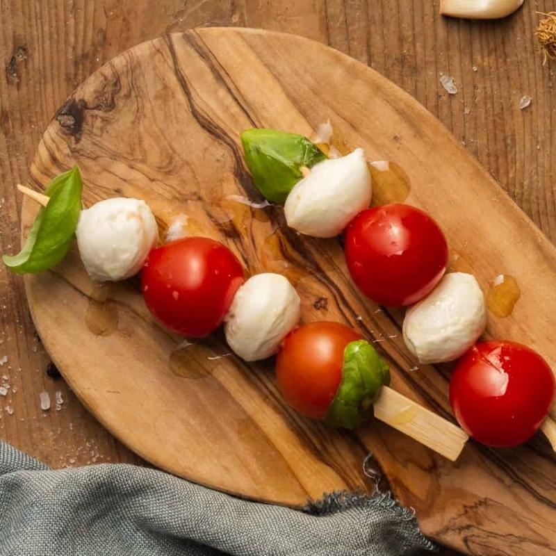 Mini-Caprese skewers with cherry tomatoes, fresh mozzarella, and basil, a festive Christmas Appetizer.