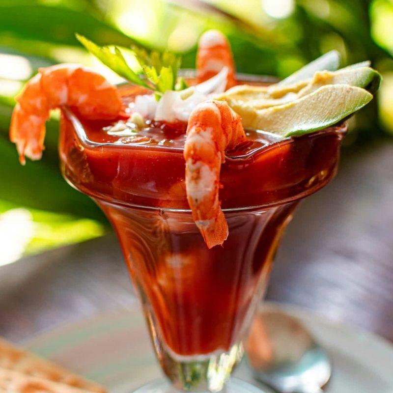 Shrimp Cocktail served in a cocktail glass as a festive Appetizer for Christmas Day with tangy sauce and garnishes.