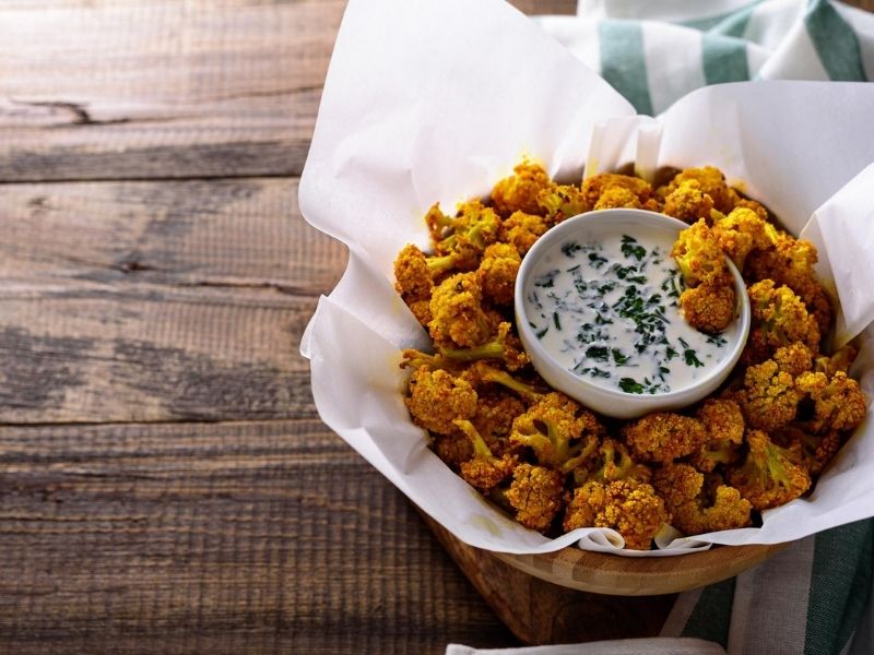 Cauliflower bites served with white sauce, a crispy and tasty low carb snack for diabetes-friendly eating.