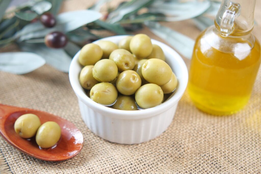 Small white pot filled with olives, a low-carb snack option for diabetes-friendly eating.